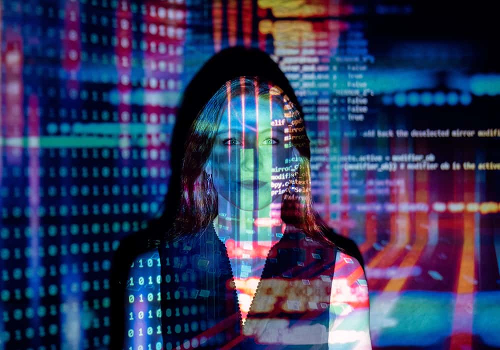 Mulher com reflexos de telas de computador no rosto